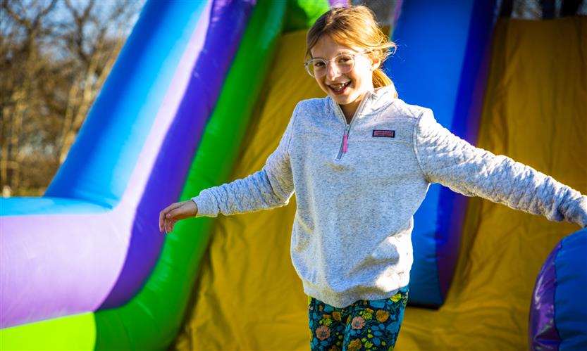 A girl runs down an inflatable slide